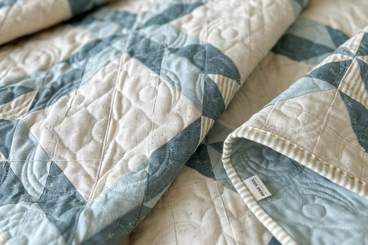 Starry Braids Quilt made by Tamara Darragh for Remi Vail Studio. Quilt is made from blue, mustard, and cream fabrics and quilted using the momentum pantograph.