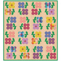 The Mary Golden Quilt quilt pattern by Tamara Darragh for Remi Vail Studio featuring a grid of colorful flower motifs on a warm cream background with pink dots and a green dot border. The flowers and leaves appear in pink, purple, blue, yellow, orange, and green, with some plaid-style centers.