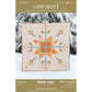 Lumi Quilt pattern by Remi Vail Studio with a geometric quilt design on a snowy background