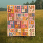 A colorful patchwork Mary Golden Quilt with floral and geometric patterns, hanging in a grassy field with trees in the background.