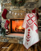 Cozy fireplace with Christmas decorations and a quilt draped over a chair.