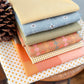Collection of various yarn dyed woven fabrics for the quilt kit associated with Lumi Quilt Pattern by Remi Vail Studio.