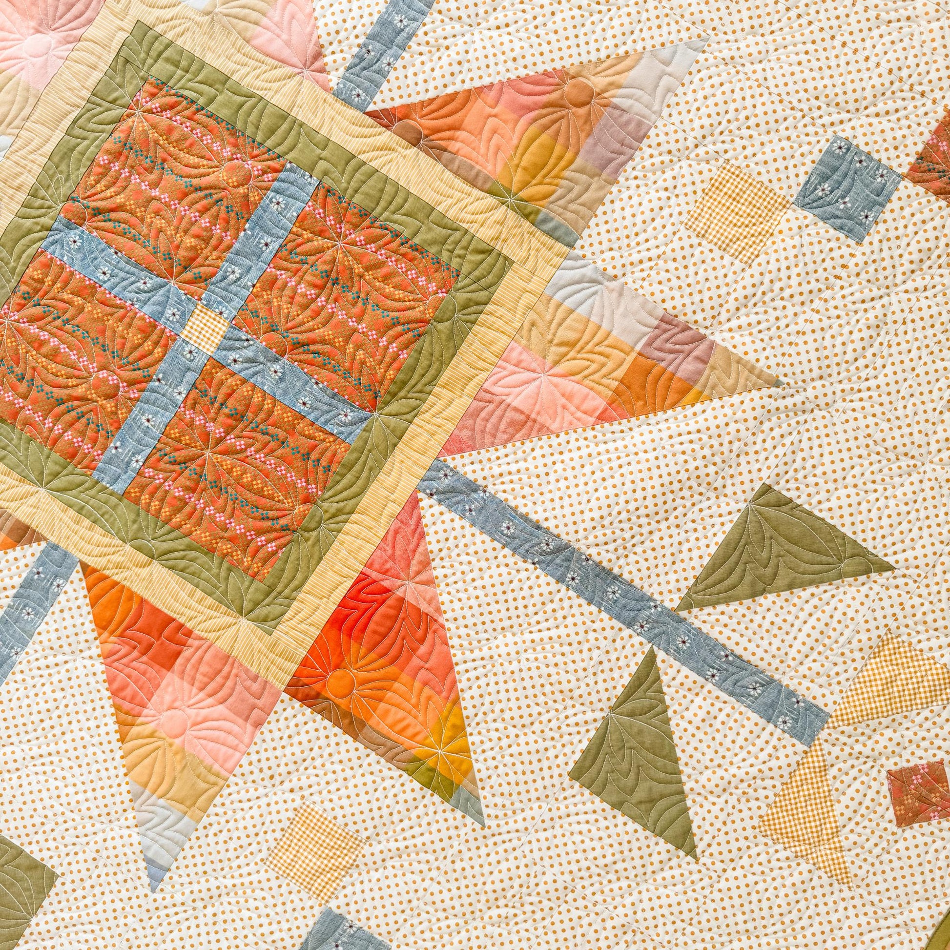 Quilt with geometric pattern on a textured beige background