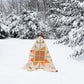 Person wrapped in a colorful quilt standing in a snowy forest