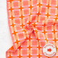 Reversible pink and orange checkered fabric on a white background