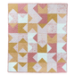 Love notes quilt flat lay on white background in colors of pink, white, and mustard yellow.