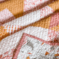 Love Notes Quilt folded with a hand stitched binding and the quilt backing showing.