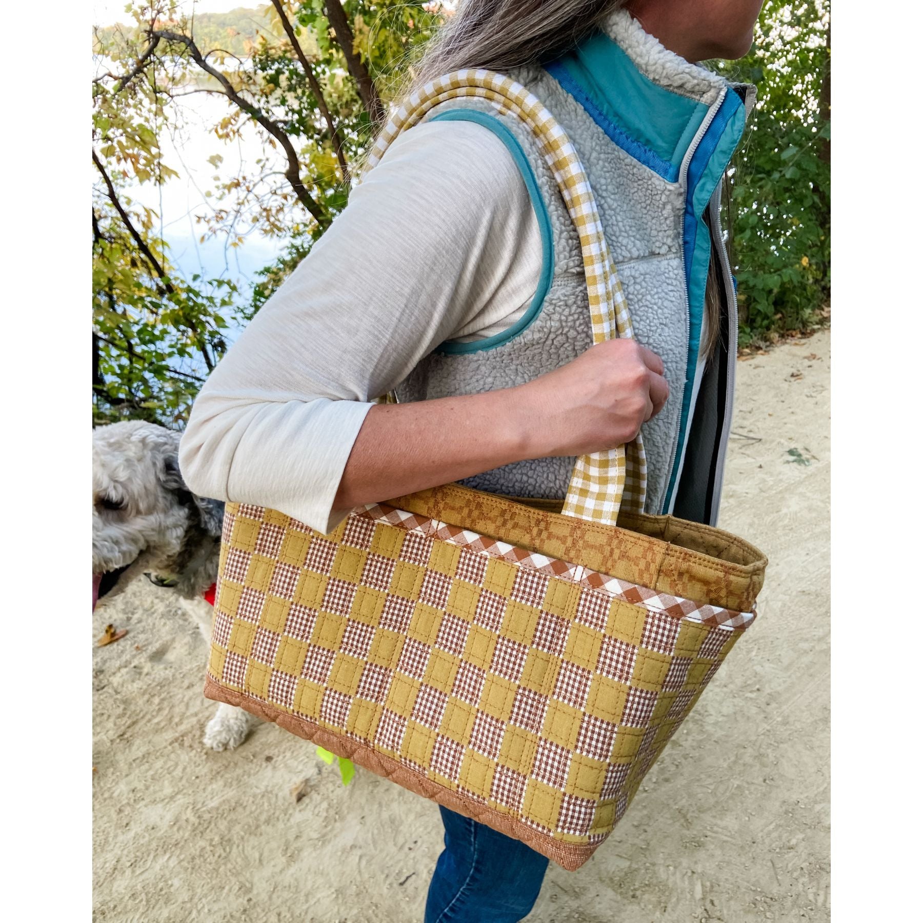 Woman holding the Maggie Poppins Tote with a blonde dog in the background.
