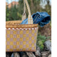 Maggie Poppins Tote made in brown, yellow, and white sitting on wood pile with denim jacket inside.