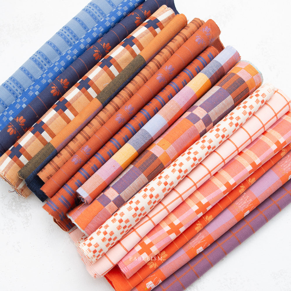Set of fabric rolls with colorful patterns on a white background