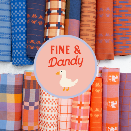 A circular pink logo overlay reading 'FINE & Dandy' with a pixel-style duck, centered over a display of colorful patterned fabric rolls. The fabrics show various designs including plaid, stripes, and floral motifs in blue, orange, pink, and brown tones.